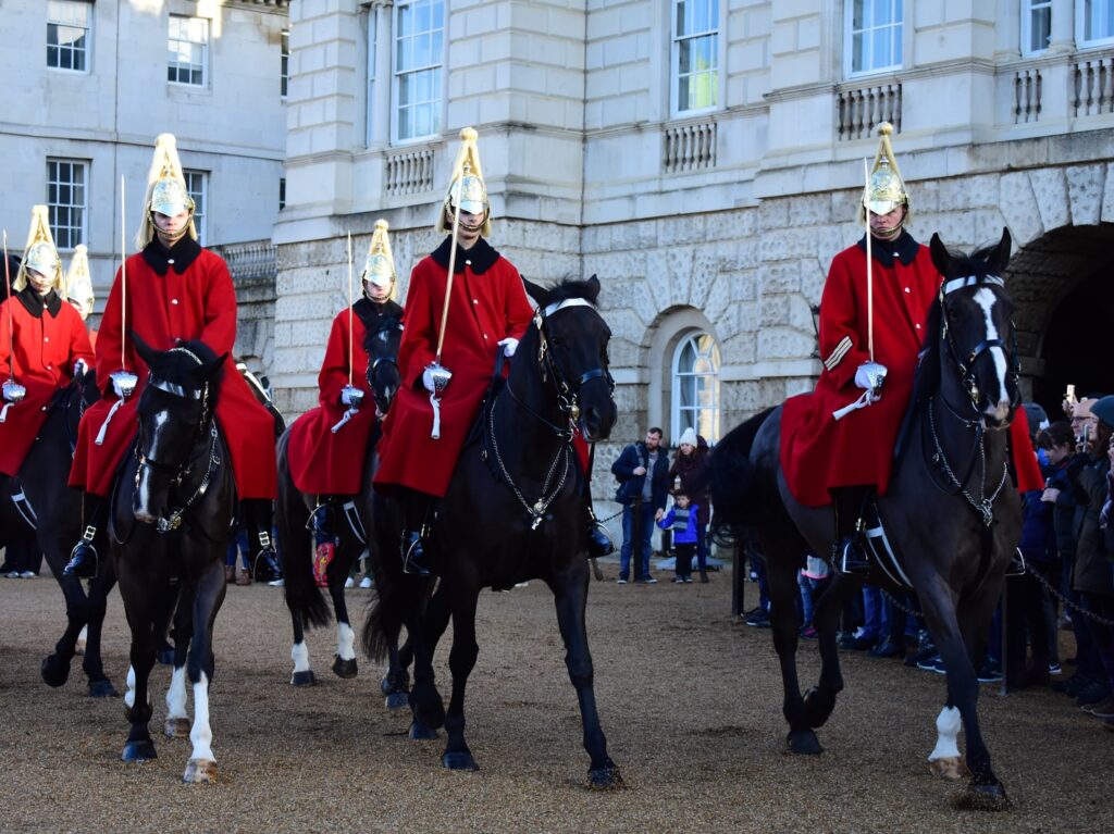 man wearing red coat riding horses during daytime