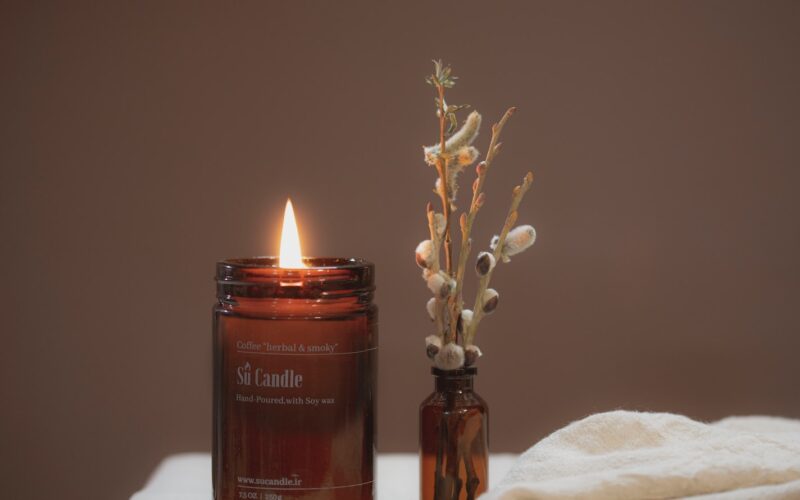 brown pillar candle on brown glass bottle
