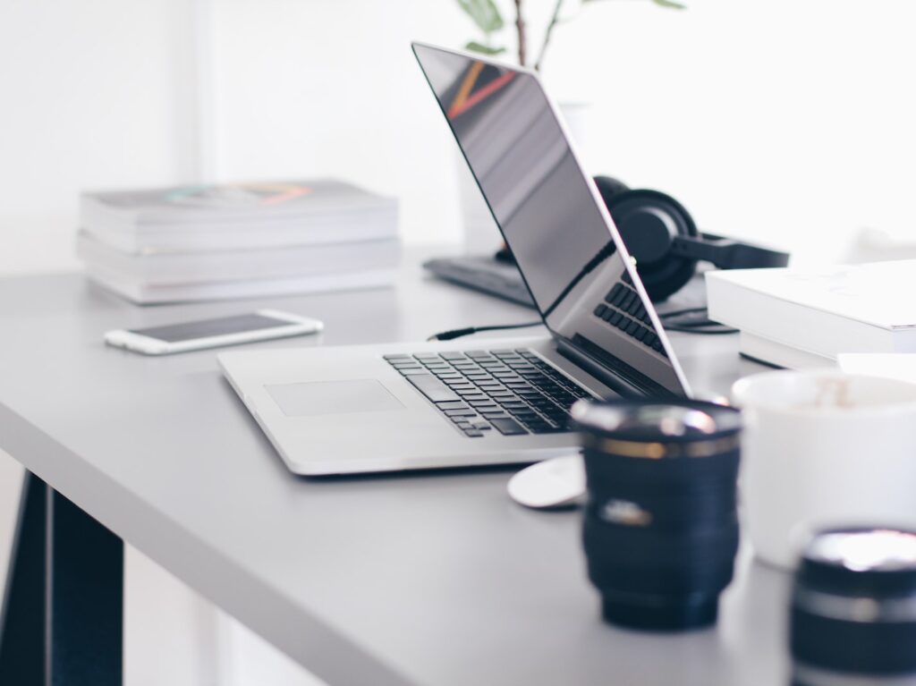 silver MacBook Pro on white table