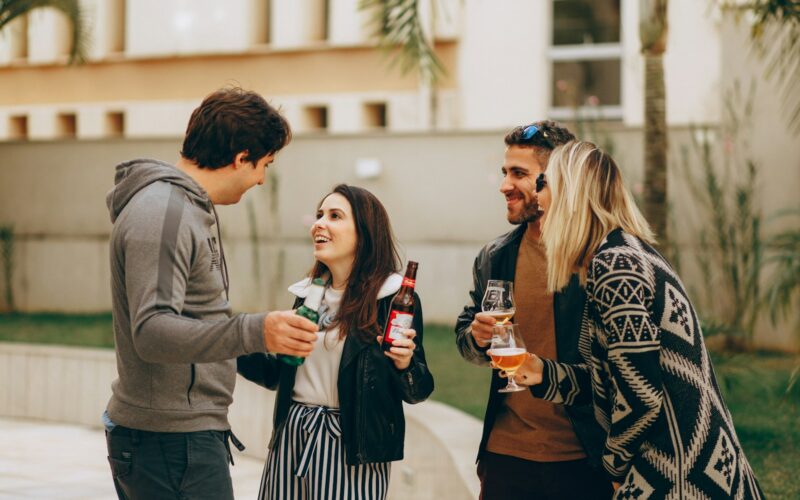 Přátelé pijí pivo a smějí se spolu