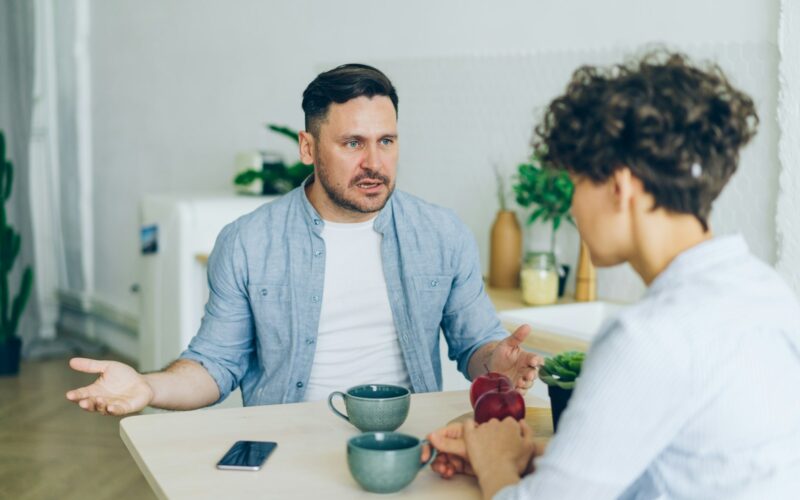 Muž sedí se ženou u stolu a hádají se